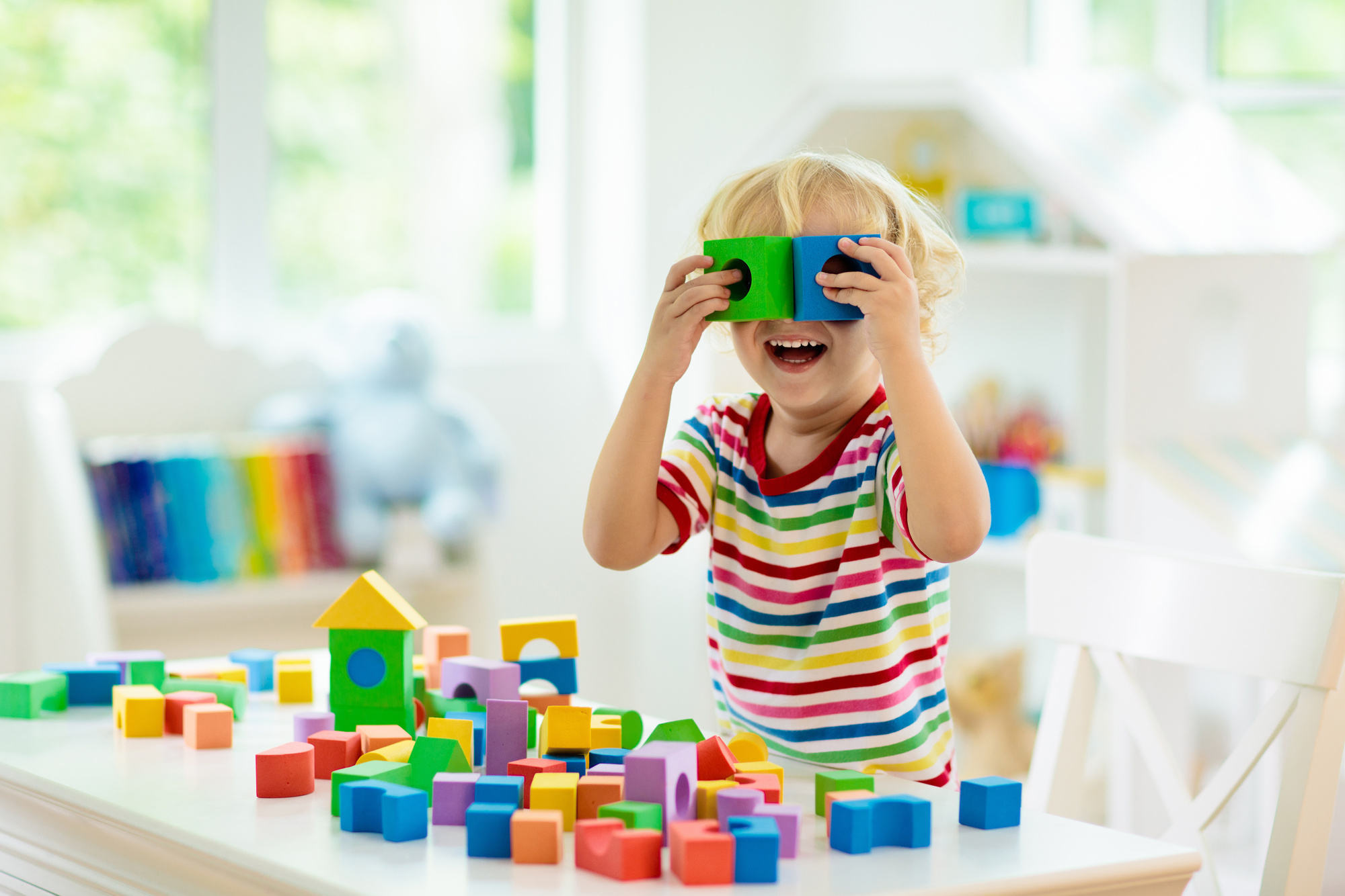 Kids toys. Child building tower of toy blocks.